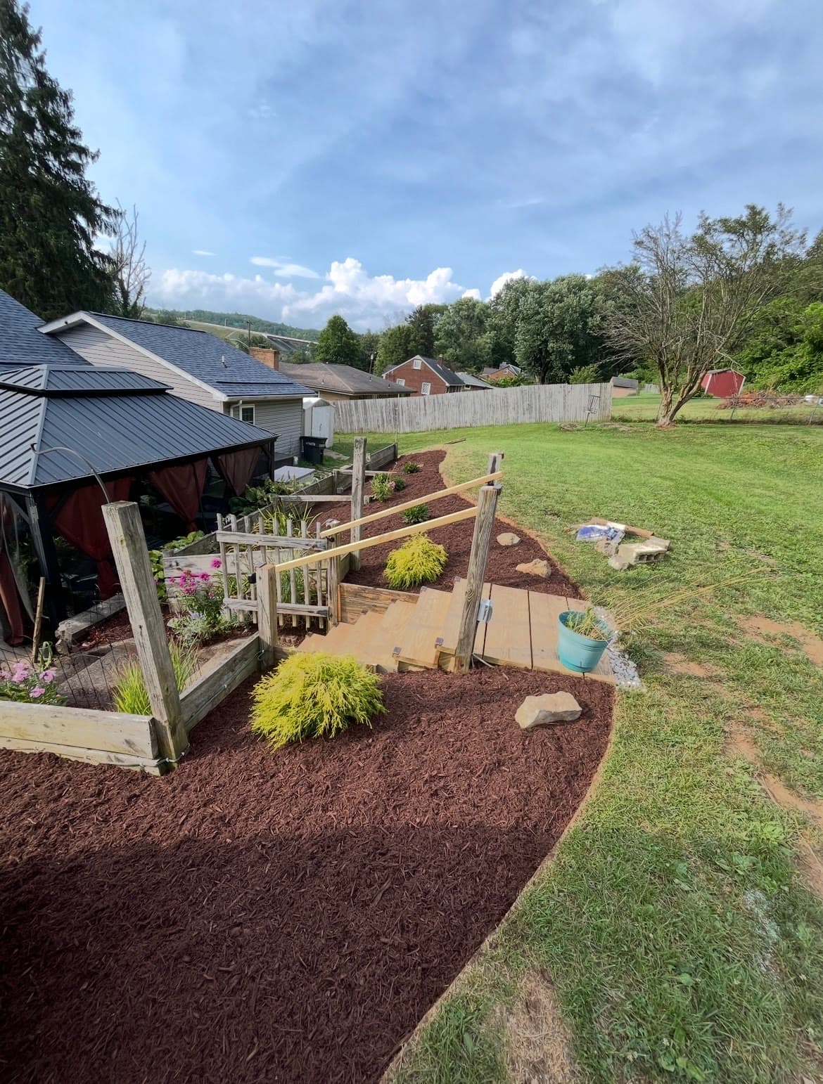 Backyard with gazebo and terraced mulched beds